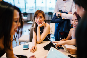 Gruppe internationaler Studierender sitzt an einem Tisch und genießt das Studentenleben in Deutschland
